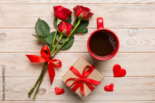 Valentine day composition with coffee cup, rose flower and gift box on table. Top view, flat lay. Holiday concept