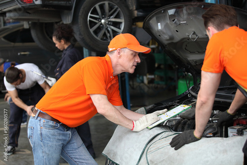 car service, repair, maintenance and people concept - auto mechanic team