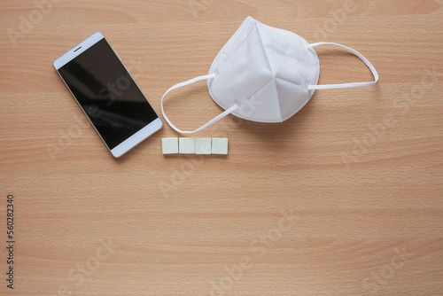 A group of white cubes with face mask and a smartphone 