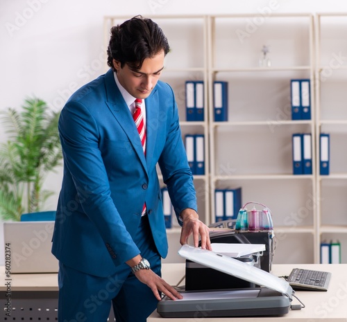 Young employee making copies at copying machine