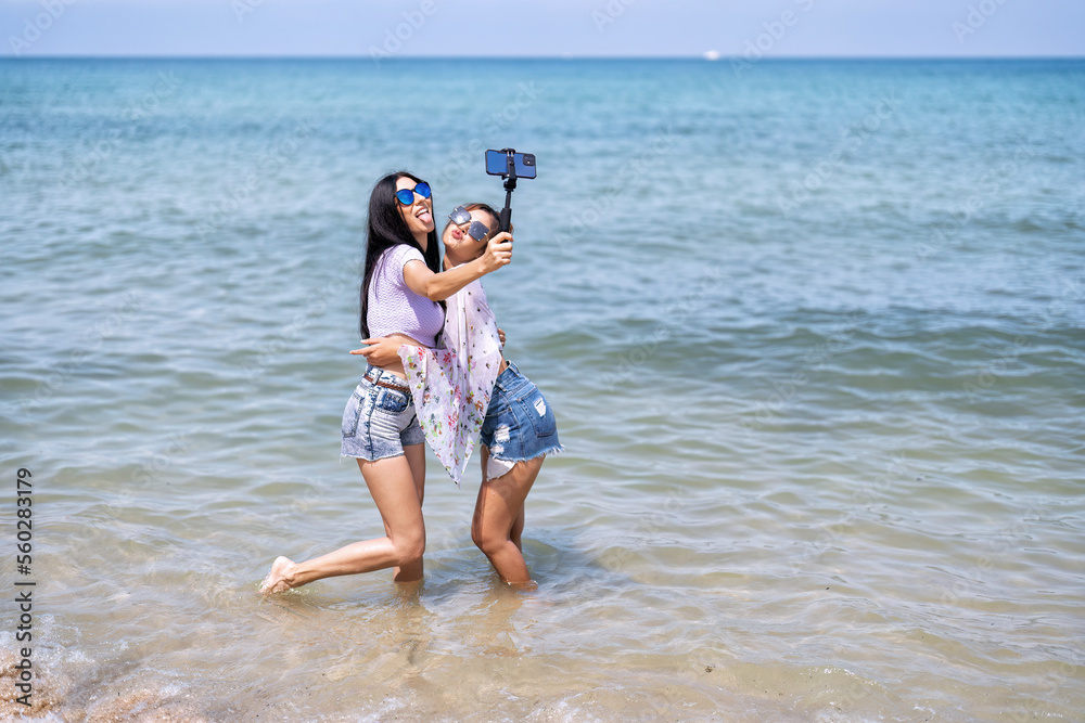 Couple LGBTQ girl on holiday happy running playing dancing along the beach on love emotion