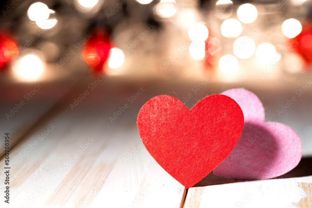 two red hearts on wooden table against defocused bokeh light background. Love, valentine's day concept. two red hearts on wooden table against defocused bokeh light background. Love, valentine's day concept.