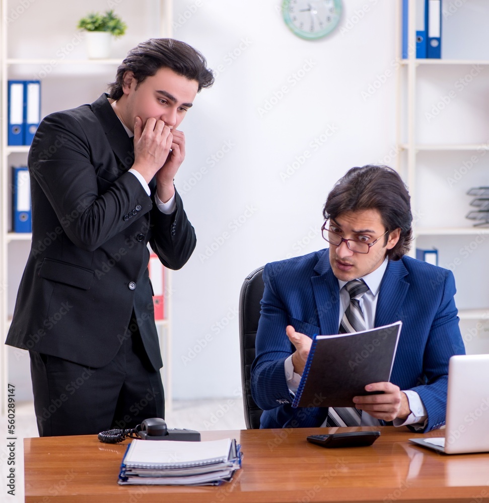 Boss and his male assistant working in the office Boss and his male assistant working in the office