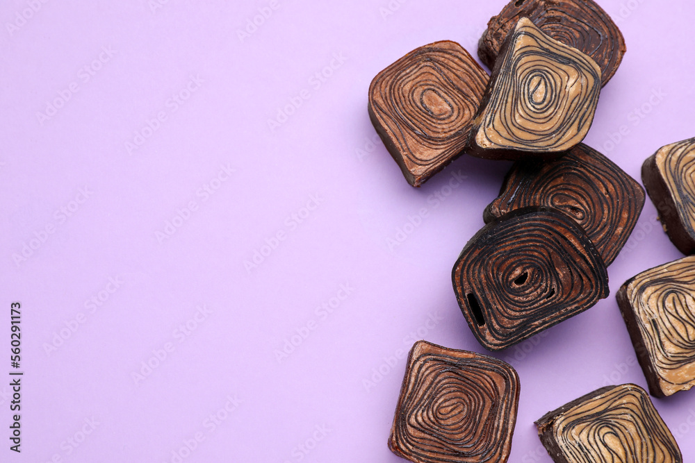 Tasty chocolate candies on violet background, flat lay. Space for text Tasty chocolate candies on violet background, flat lay. Space for text
