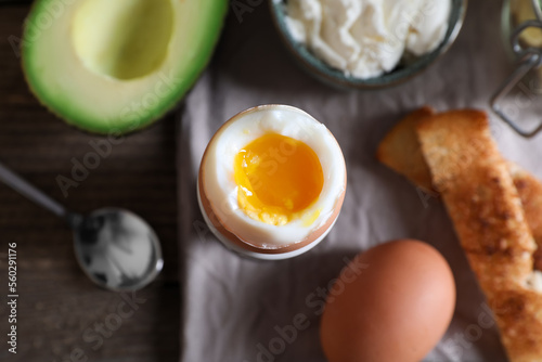 Canvas Print Soft boiled egg served for breakfast on wooden table, flat lay