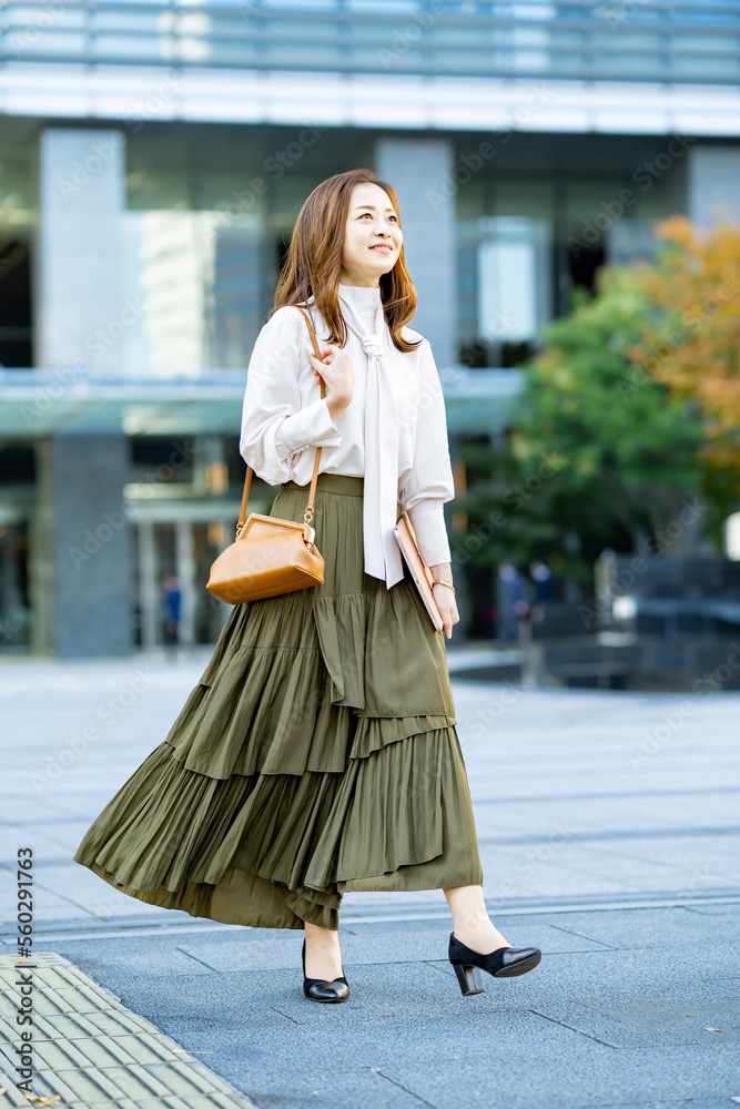Fototapeta premium オフィスカジュアルスタイルで通勤する女性