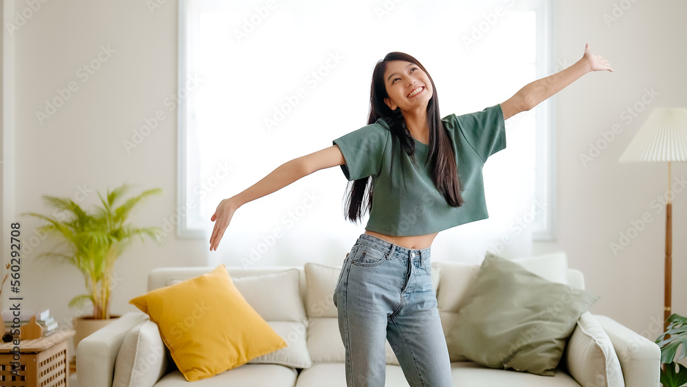 Young asian woman dancing on the floor in living room at home. Happy asia female smile relaxing in house, healthy mental wellness and wellbeing Young asian woman dancing on the floor in living room at home. Happy asia female smile relaxing in house, healthy mental wellness and wellbeing