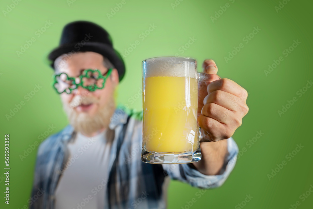 Funny bearded man celebrates St. Patrick's Day and holds mugs of beer Funny bearded man celebrates St. Patrick's Day and holds mugs of beer