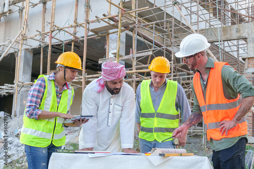 Diverse team of professionals using tablet computers on construction site. Real estate construction project. with civil engineers, architects, Arabic business investors and explorer with theodolite Diverse team of professionals using tablet computers on construction site. Real estate construction project. with civil engineers, architects, Arabic business investors and explorer with theodolite