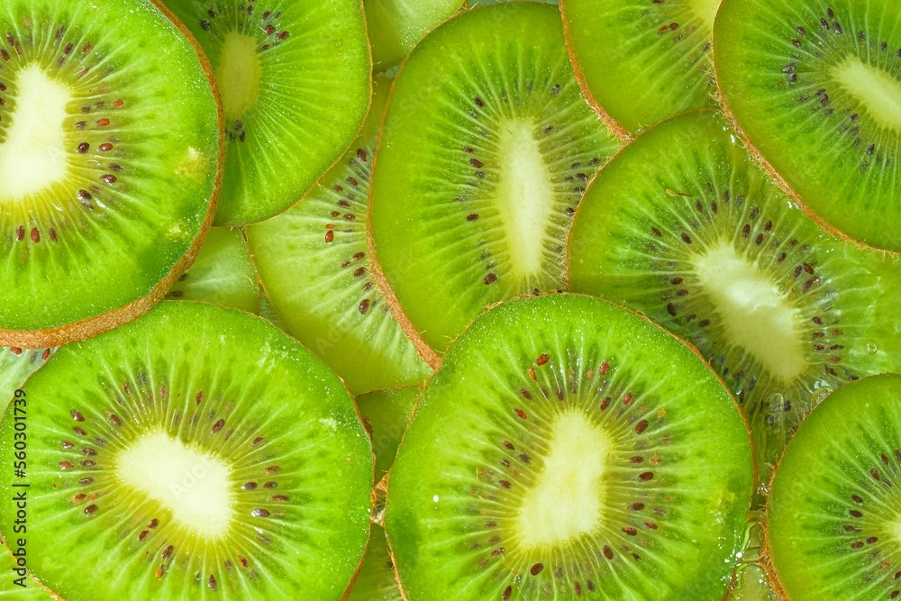 Kiwi fruit close-up in liquid with bubbles. Slices of gren ripe kiwi fruit in water. Close-up fresh slices of green kiwi fruit on white background. Top view, flat design Kiwi fruit close-up in liquid with bubbles. Slices of gren ripe kiwi fruit in water. Close-up fresh slices of green kiwi fruit on white background. Top view, flat design