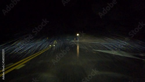 Night driving through heavy rain on curvy canyon mountain road.