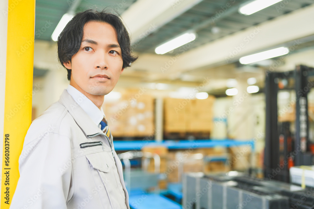 Fototapeta premium 作業服を着て倉庫で働く若いビジネスマン