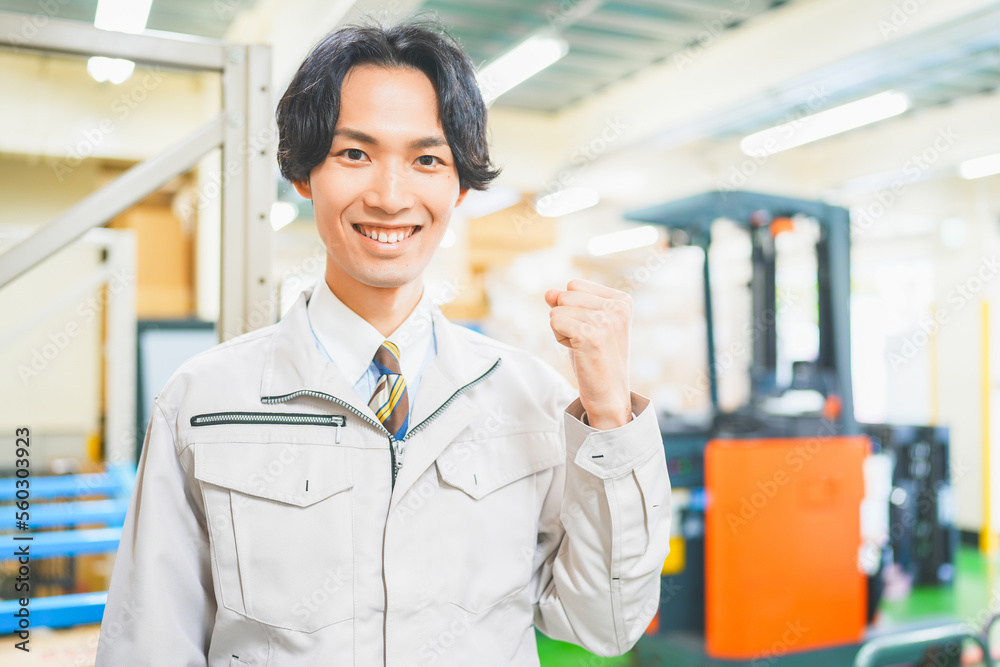 © HML - 作業服を着て倉庫でガッツポーズをする若いビジネスマン © HML - 作業服を着て倉庫でガッツポーズをする若いビジネスマン