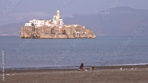 Woman in the beach of Al-Hoceima, Morocco, with the spanish Alhucemas island in front. Slow motion. photo