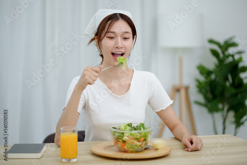 Cheerful young  Asian woman happy eating healthy food