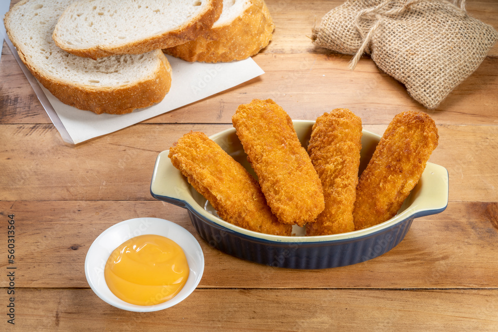 Fish fingers or fish sticks grilled, shallow deep-fried in dish on Table background ready to eat.