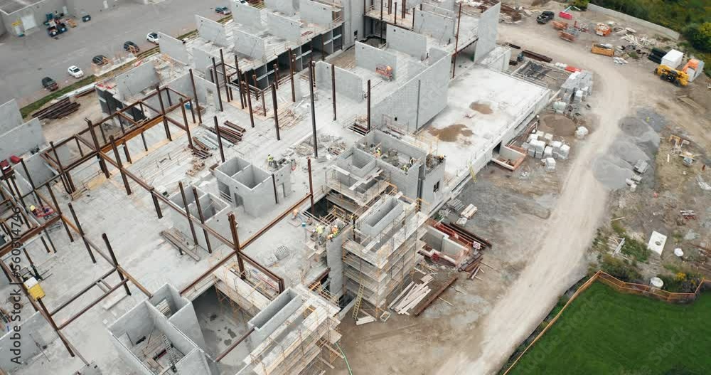 Aerial Flight Over New Commercial Building Under Development with Employed Union Construction Site Workers Operating Heavy Machinery Jobs. Industrial Urban Real Estate Apartment Housing Flyover 4K Aerial Flight Over New Commercial Building Under Development with Employed Union Construction Site Workers Operating Heavy Machinery Jobs. Industrial Urban Real Estate Apartment Housing Flyover 4K