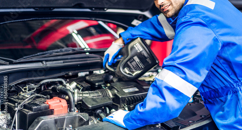 Professional car technician mechanic team in uniform work fixing vehicle car engine and maintenance repairing checking under the car hood in auto service. Automobile service garage © Art_Photo