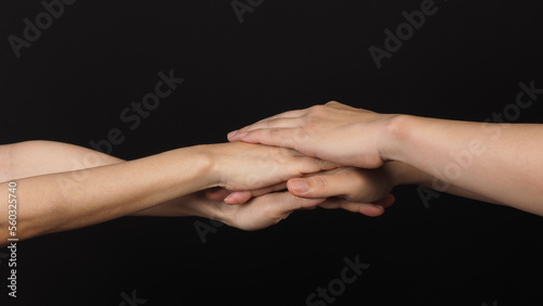 Hands, solidarity and teamwork .Unity or agreement of feeling on black background.