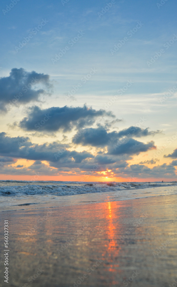 Fototapeta premium Sunset on a beach in Acapulco, Pie de la Cuesta beach, sun setting to the horizon in Mexico