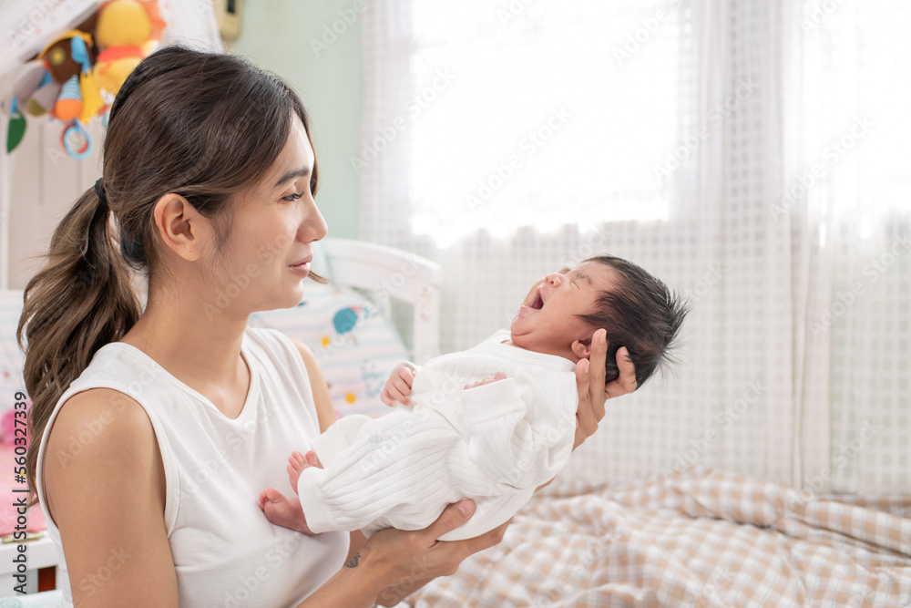 happy loving family. mother playing with her baby hugging in the bedroom , portrait of asian mother playing with newborn baby, health care family love together. asian girl lifestyle.. happy loving family. mother playing with her baby hugging in the bedroom , portrait of asian mother playing with newborn baby, health care family love together. asian girl lifestyle..