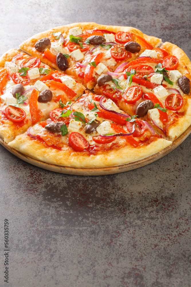 Fresh Homemade Vegetarian Greek Pizza with feta and vegetables closeup on the wooden board on the table. Vertical