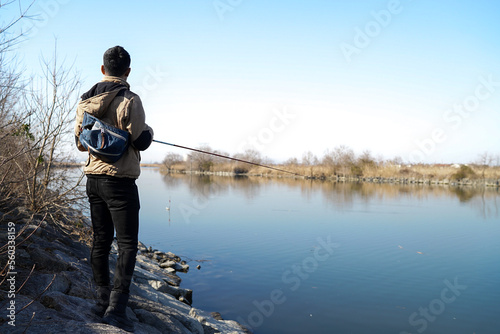 真冬の川でバス釣りをする男性