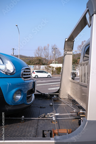 積載車でレッカー移動をする青い輸入車 © 翔吾 荒木
