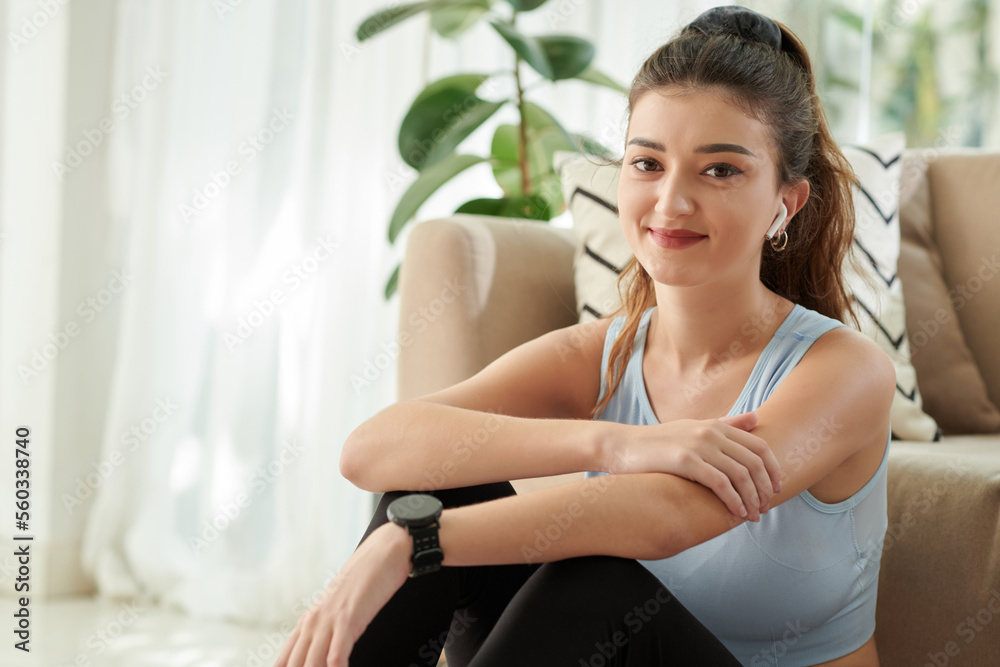 Portrait of smiling lovely young woman resting on floor after working out at home Portrait of smiling lovely young woman resting on floor after working out at home