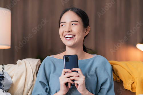 happiness asian female adult woman preparing travel trip packing wearing casual cloth enjoy unpack suitcase luggage and text chat with her friend joyful laugh smile travel and vacation concept