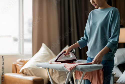 young asian adult female woman ironing her cloth at home,Portrait of a happy woman ironing her clothes at home and smiling lifestyle concepts in living room at home housewife daily routine