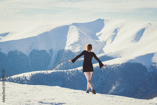 Attractive woman in short dress on mountain scenic photography. Picture of person with snow capped peaks on background. High quality wallpaper. Photo concept for ads, travel blog, magazine, article