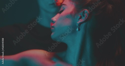 Man and woman dance closely in orange rays of light
