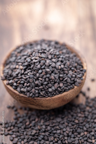 Bio natural black sesame seeds on wooden bowl.