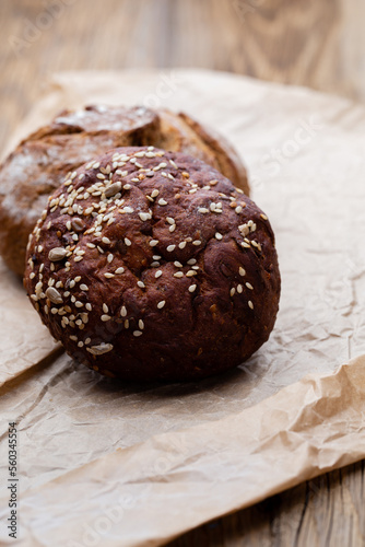 Gold rustic crusty loaves of bread and buns on wooden background. Still life captured from above top view, flat lay.