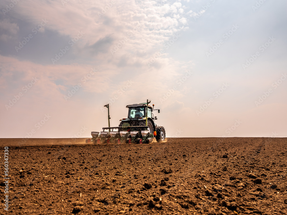 Farmer using a tractor to sow soybean seeds in a field Farmer using a tractor to sow soybean seeds in a field