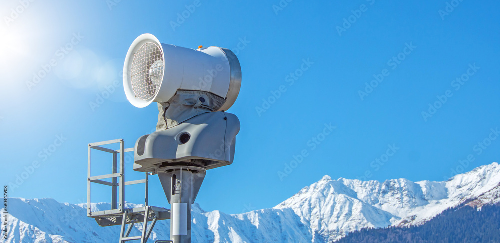Snow making machine against the background of snow-capped mountains with a forest, sunbeam sunshine. Snow making machine against the background of snow-capped mountains with a forest, sunbeam sunshine.