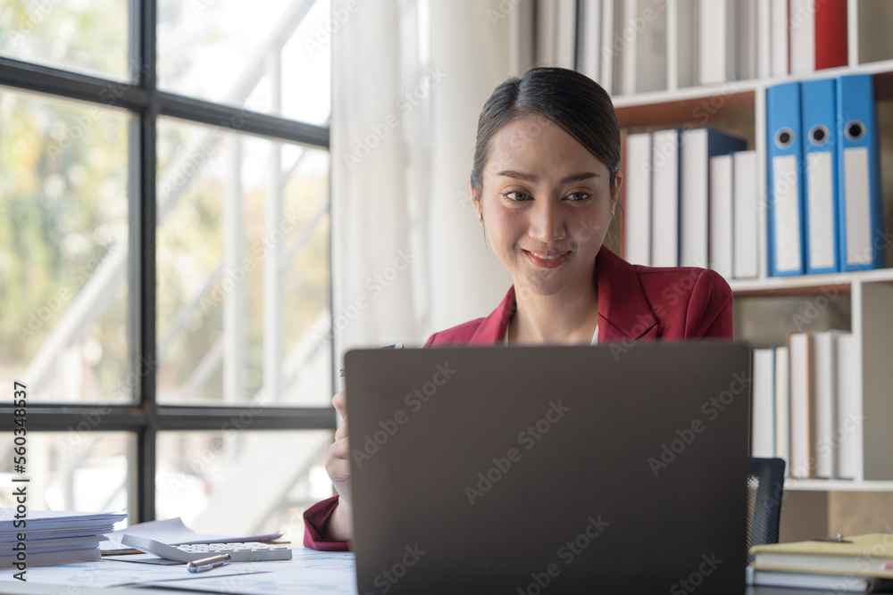 Beautiful young Asian girl working at a office space with a laptop. Concept of smart female business. Beautiful young Asian girl working at a office space with a laptop. Concept of smart female business.