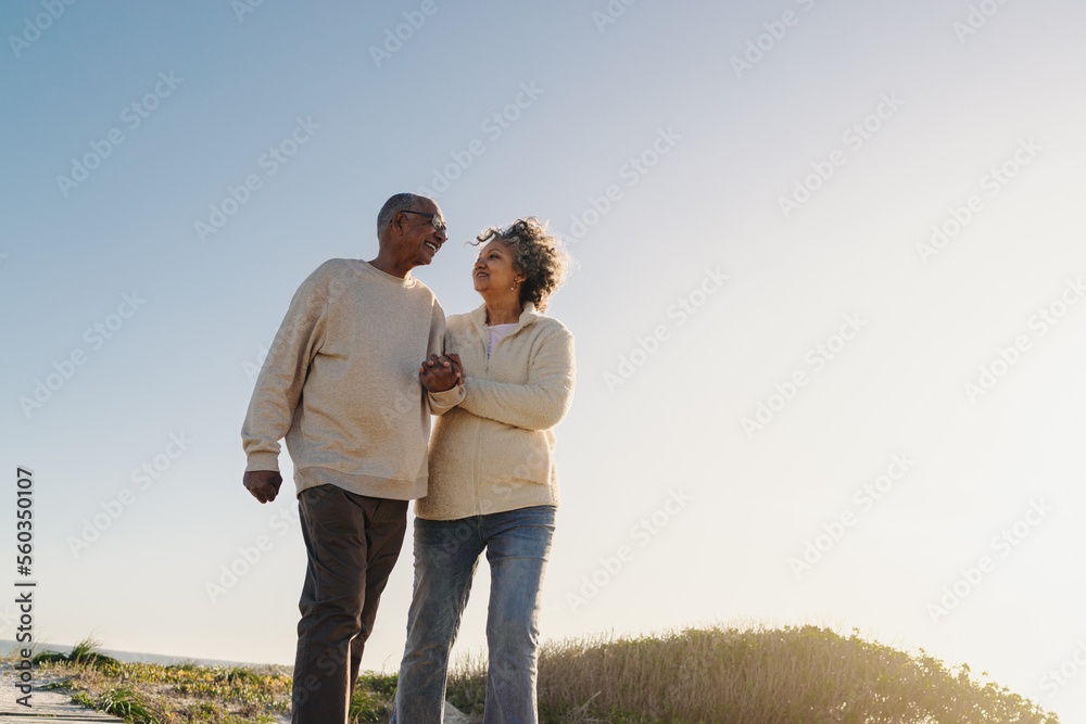 Low angle view of a senior couple walking down a foot bridge at the beach