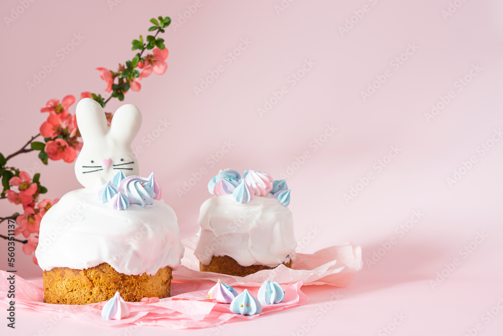 Easter cake and colorful eggs and Easter decorative bunny on a pink background with spring cherry blossoms and copy space. Easter Ukraine orthodox sweet bread.Easter card concept.