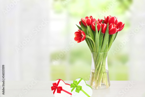 Happy Valentines Day greeting card. Decorative bouquet of tulips over blurred natural background. Concept of holidays, postcard, Mothers Day, Banner and 8 March. Space.