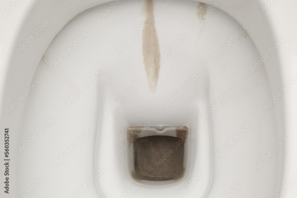 Dirty toilet bowl with limescale stain deposits. A toilet with traces