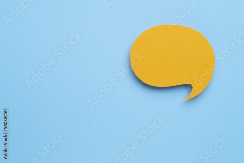 Paper speech bubble on light blue background, top view. Space for text