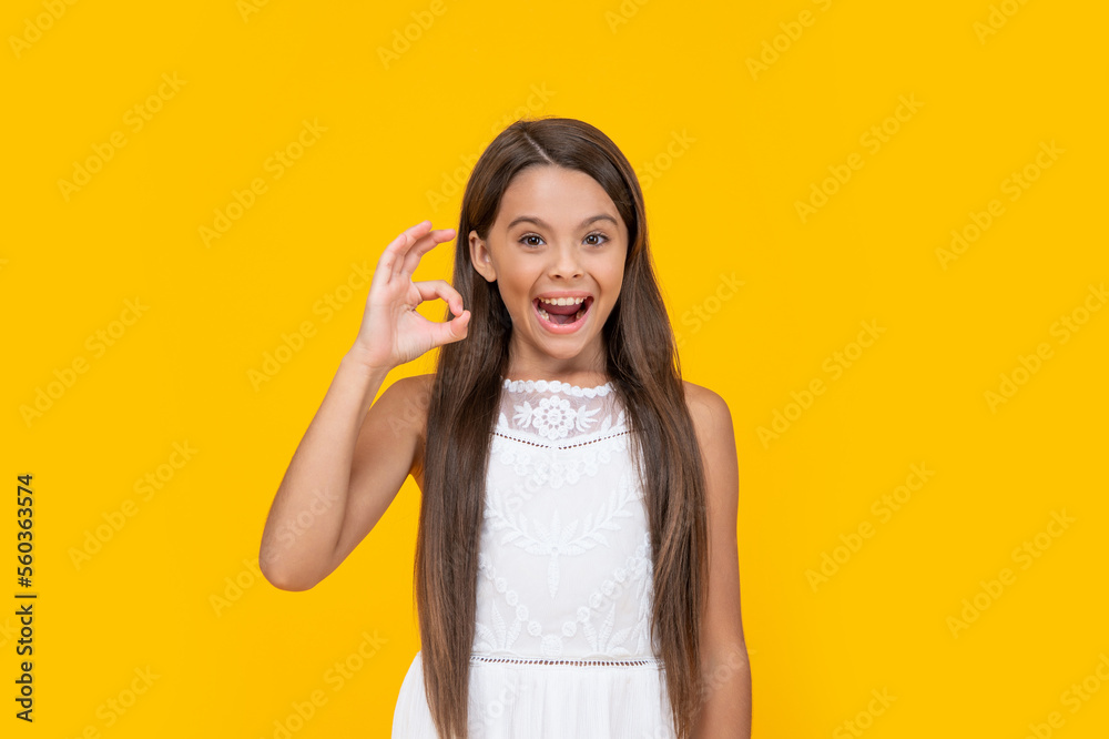 cute teen girl in white dress has long hair on yellow background. ok cute teen girl in white dress has long hair on yellow background. ok