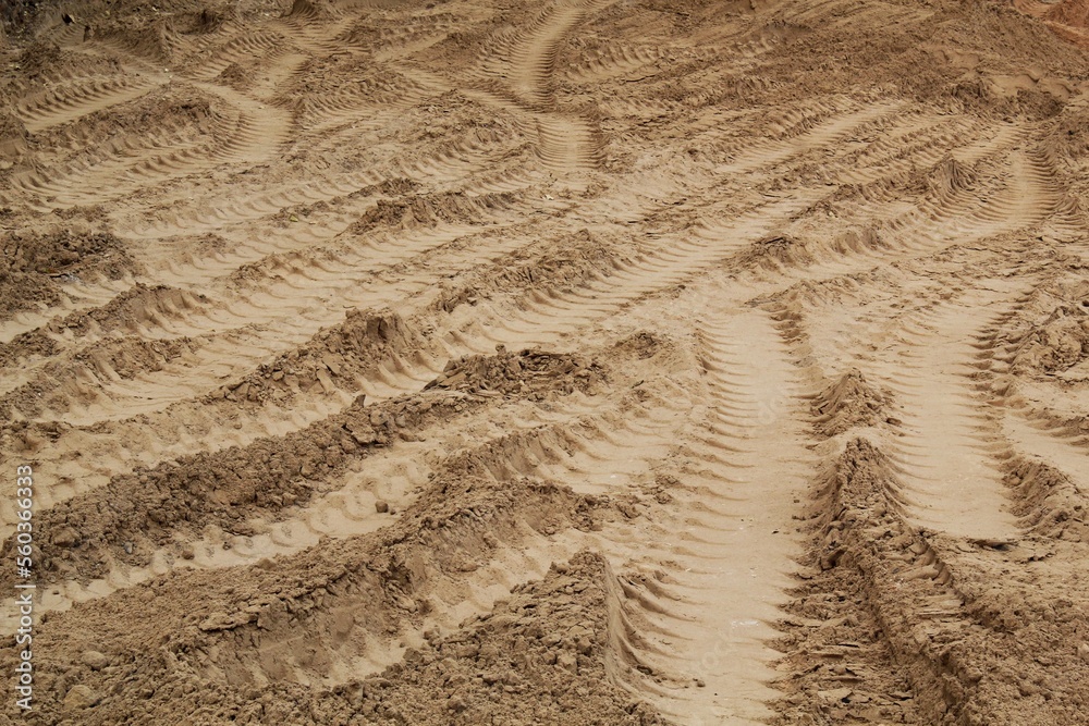 Tire track mark lines shape on dry sand background. Trail tyre imprint from heavy machinery. Vehicle shape. Road construction site backdrop concept. Trace of wheel pattern on mud. Nature texture. Tire track mark lines shape on dry sand background. Trail tyre imprint from heavy machinery. Vehicle shape. Road construction site backdrop concept. Trace of wheel pattern on mud. Nature texture.