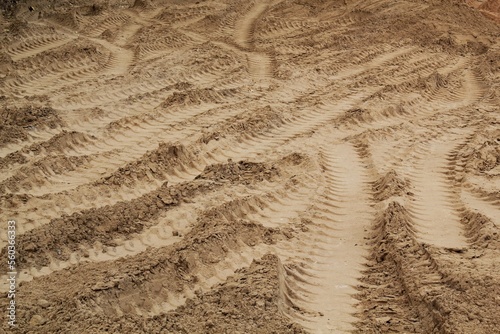 Tire track mark lines shape on dry sand background. Trail tyre imprint from heavy machinery. Vehicle shape. Road construction site backdrop concept. Trace of wheel pattern on mud. Nature texture.