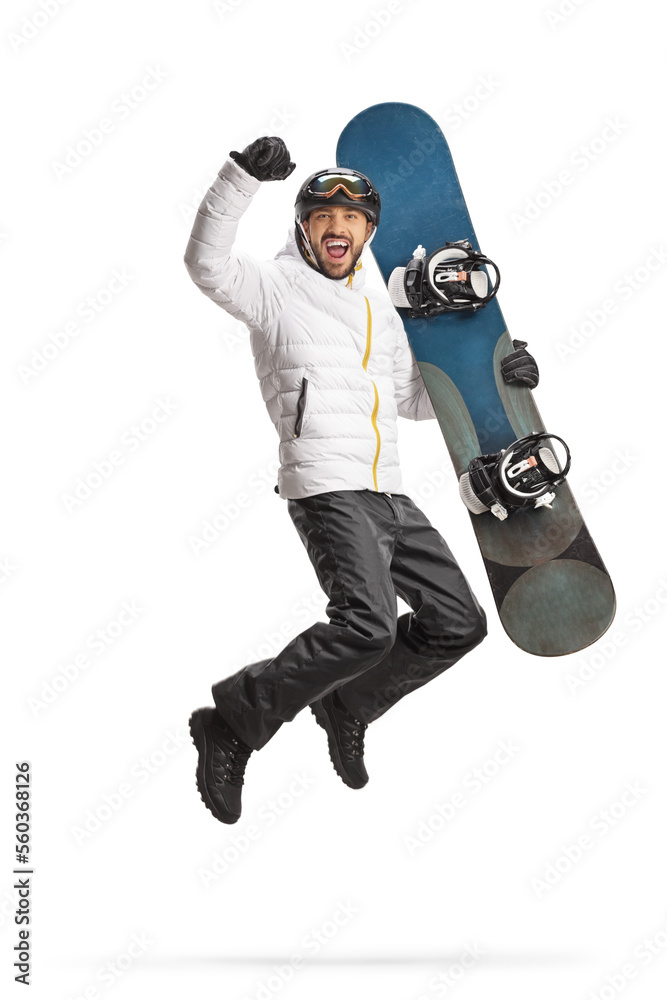 Happy young man holding a snowboard and jumping Happy young man holding a snowboard and jumping