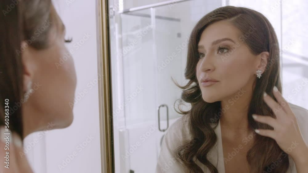 Bride looking in the mirror, putting on wedding day earrings. Young bride smiling. 4K 60 FPS. Email willneathery yahoo.com to purchase entire wedding event at wholesale price.