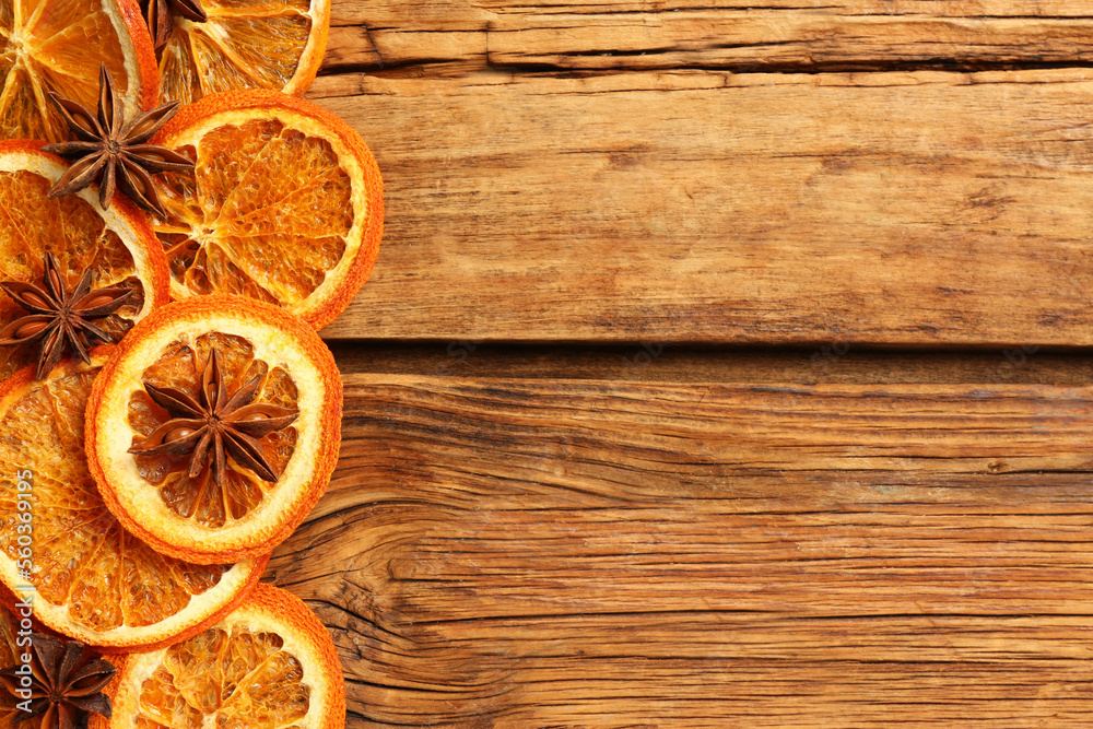 Dry orange slices and anise stars on wooden table, flat lay with space for text Dry orange slices and anise stars on wooden table, flat lay with space for text