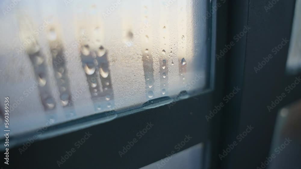 Cold weather as water condensation appears on window droplets drip down glass. Condensation on